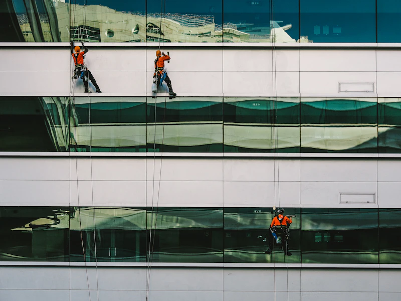 man cleaning white building facade