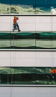 man cleaning white building