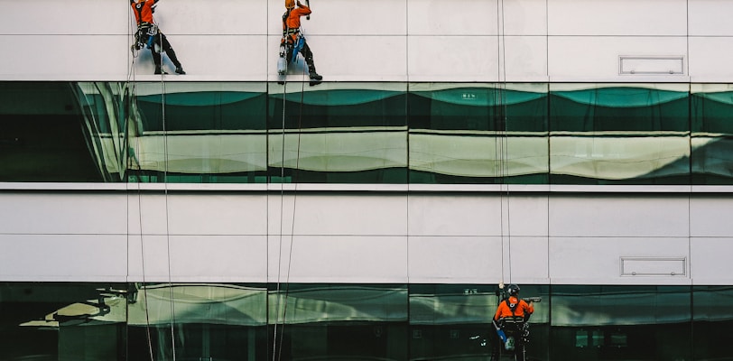 man cleaning white building