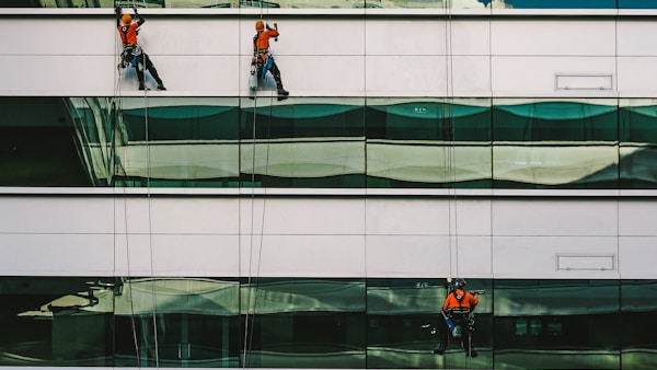 man cleaning white building