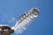 person holding a feather under blue sky