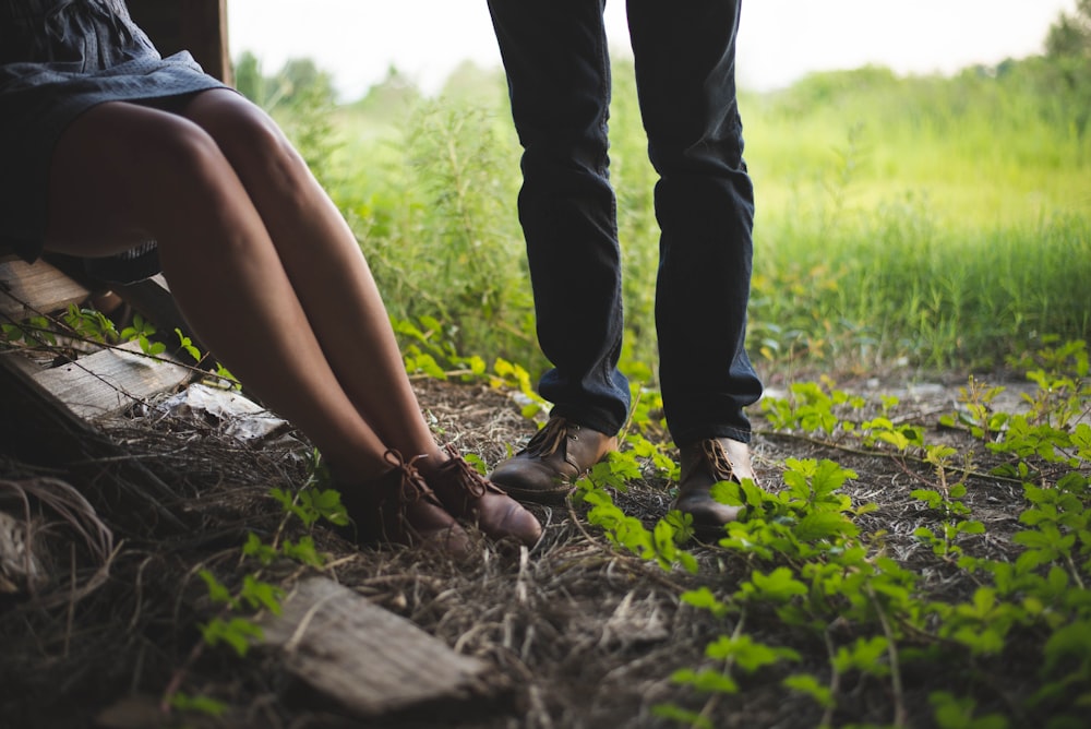 man and woman standing and sitting beside each other