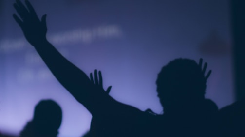 Crowd silhouettes raising hands in front of a glowing neon sign reading 'af.tease nyc'.