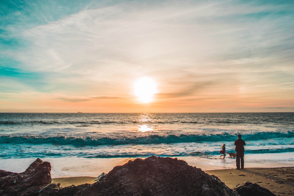 homem na praia durante o pôr do sol