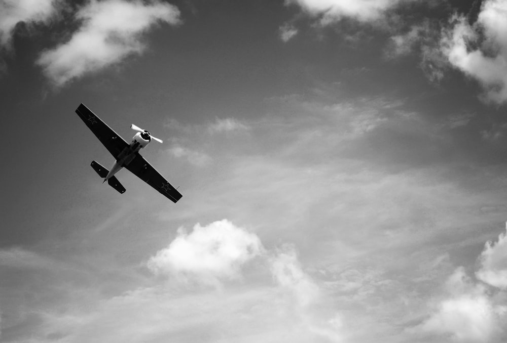 fotografia in scala di grigi di un aereo in volo