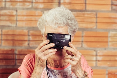 woman holding film camera mature teams background
