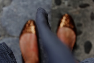 A pair of glittery high-heeled shoes catching the light on a marble floor.