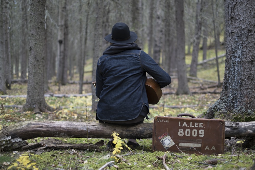 person playing guitar in forest