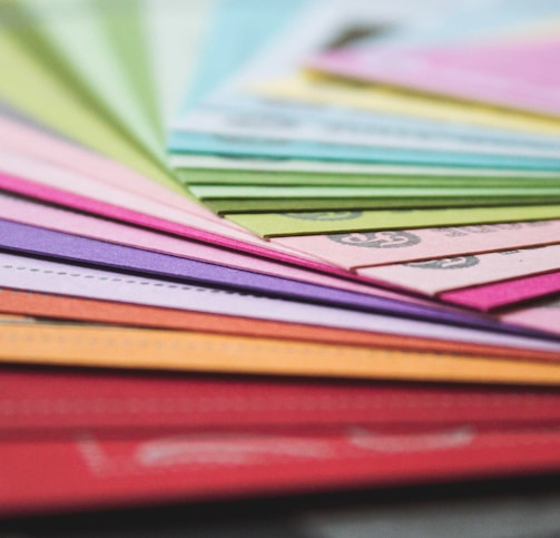 a close up of many different colored papers