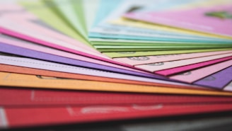 a close up of many different colored papers