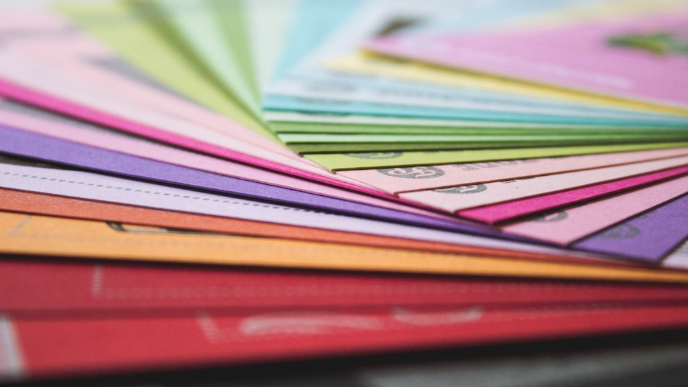 a close up of many different colored papers