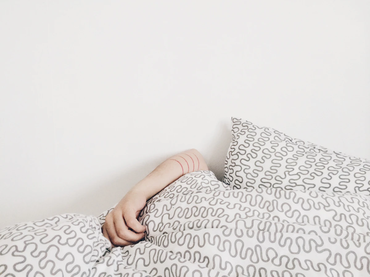 Person lying awake in bed at night, a common presentation of insomnia