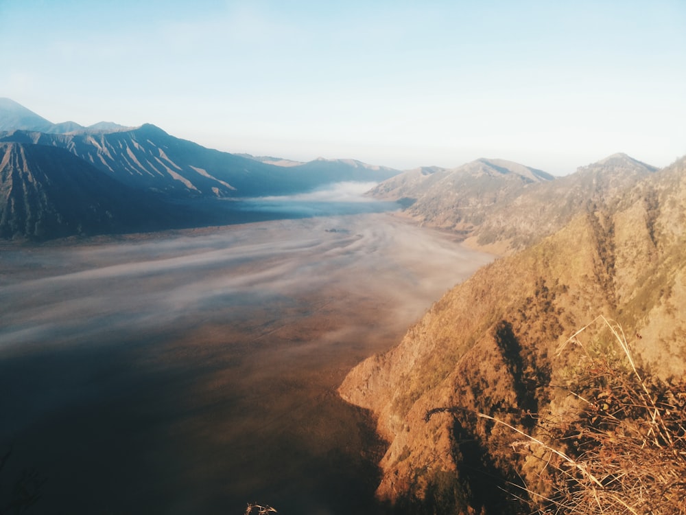 flat land surrounded by mountains during daytime