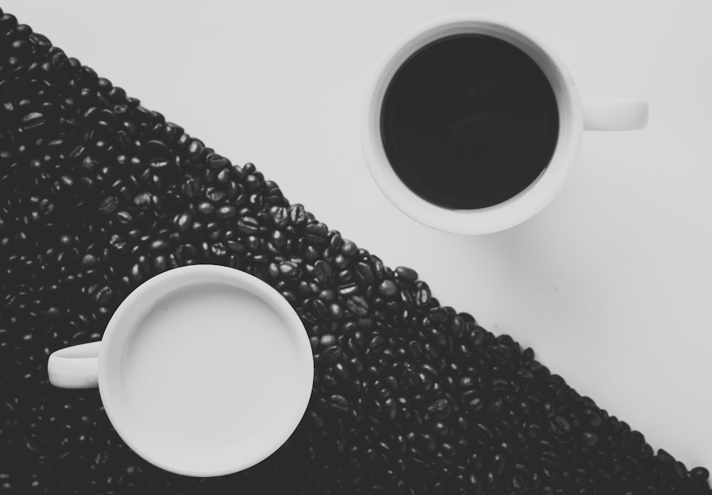 검은 액체로 채워진 흰색 세라믹 커피 머그잔