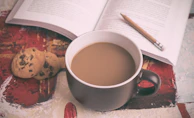 A cozy scene of a journal page beside a steaming cup of tea, inviting quiet moments of contemplation.