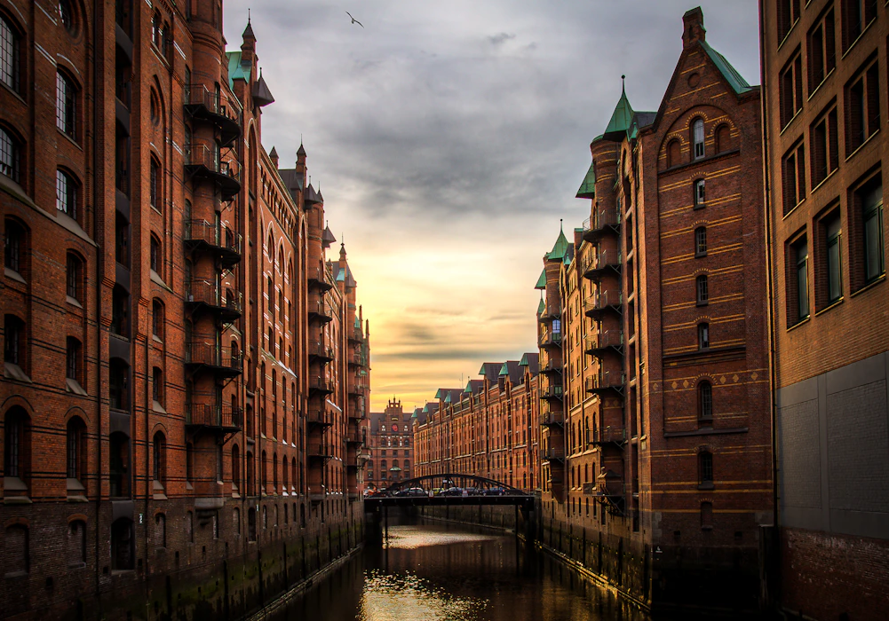 A historic northern-European old-town quarter of brick facades and waterways glowing in the late-afternoon light
