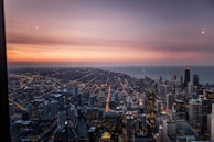 A panoramic view of Karachi's skyline at sunset with the city lights beginning to glow.