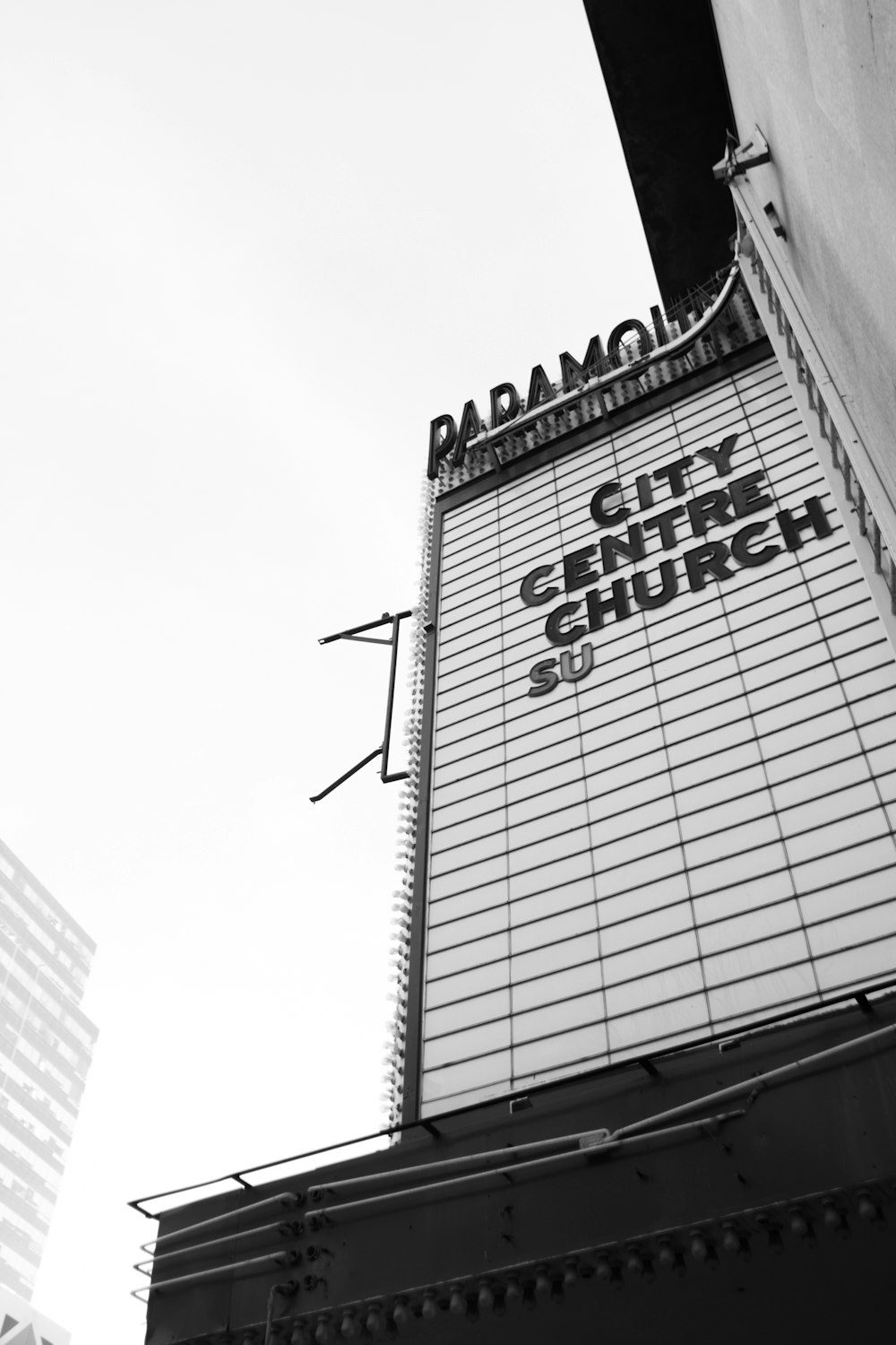 Una foto en blanco y negro del letrero de la iglesia del centro de la ciudad