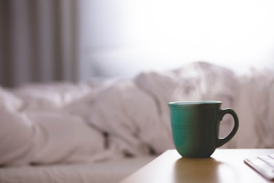 green ceramic mug on nightstand