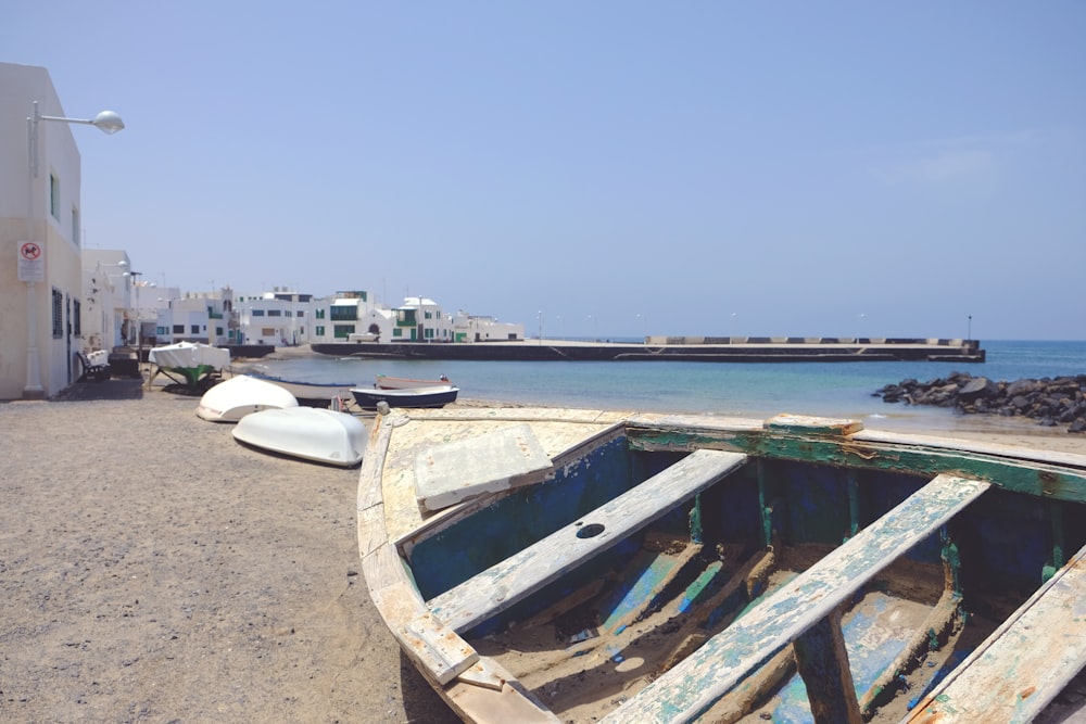 Barco blanco y azul en la playa durante el día