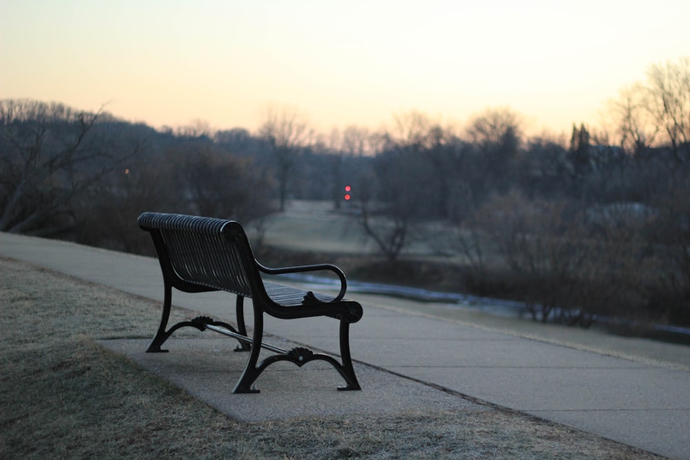 black bench on concrete pavement