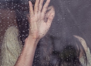 woman touch rainy glass