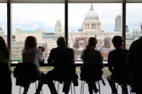 A team of consultants discussing financial plans around a table with city skyline in the background.