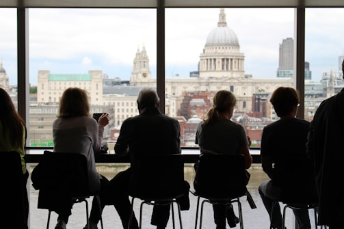 A team of consultants discussing financial plans around a table with city skyline in the background.
