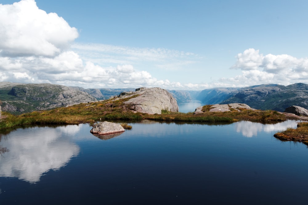 reflective photography of mountains near body of water