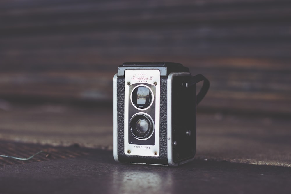 Fokusfoto einer schwarz-grauen Vintage-Kamera auf brauner Oberfläche