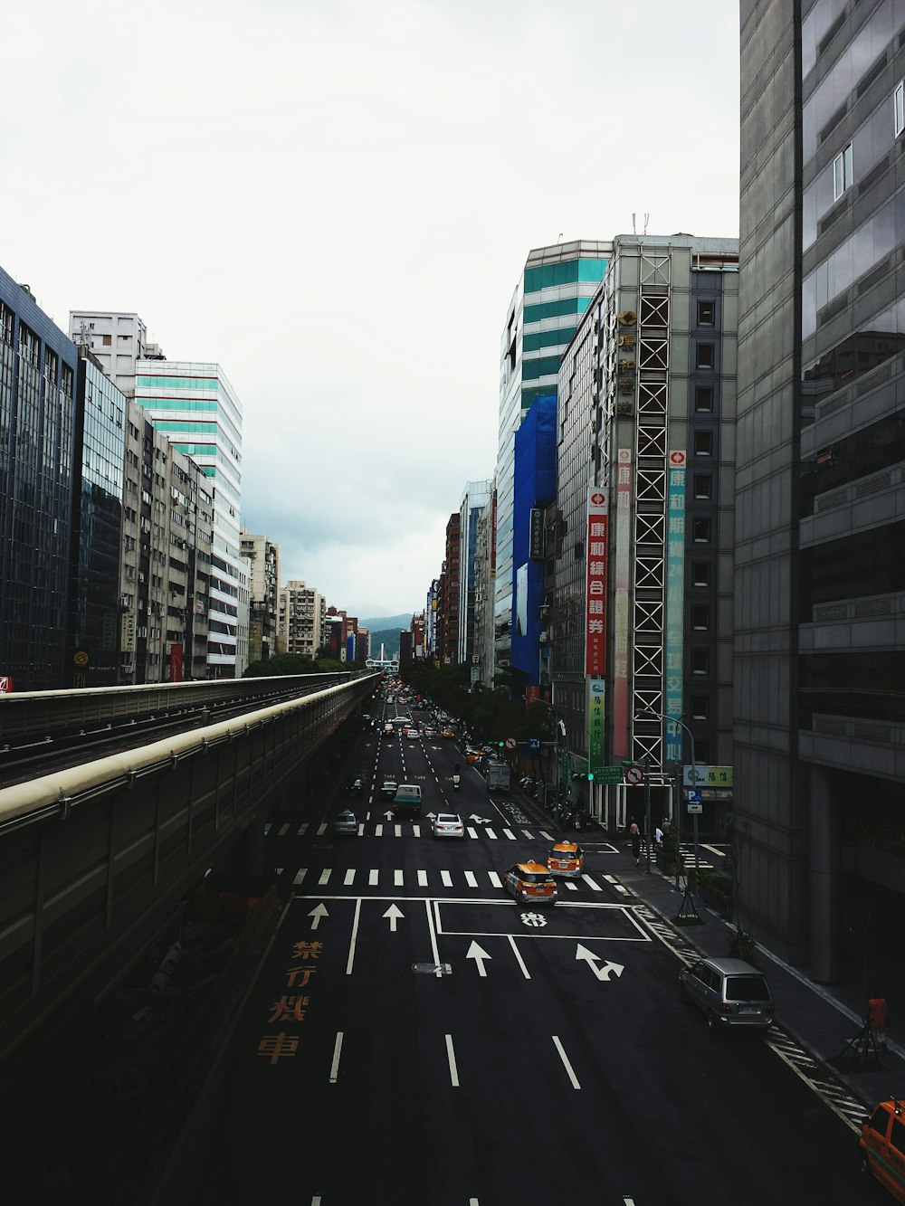 concrete buildings and road with cars passing