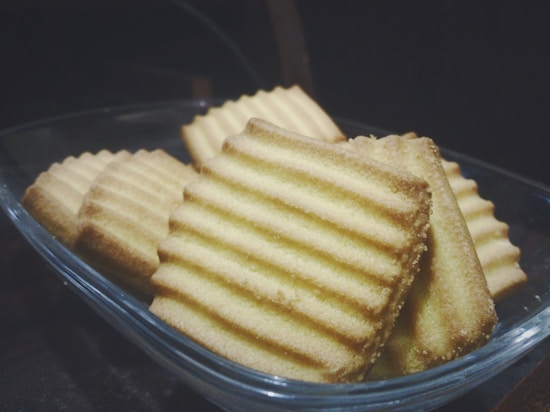 A glass dish contains several rectangular cookies with a striped pattern on top. The cookies have a golden-brown appearance, suggesting they are baked. They are arranged closely together, filling the dish.