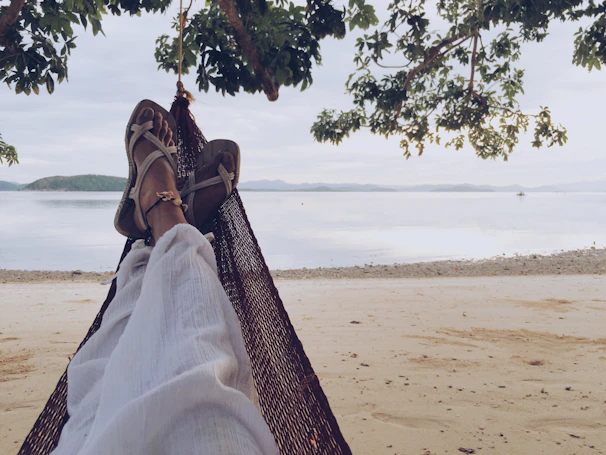 A traveler enjoying a peaceful moment on a beach hammock with the Maldives horizon in view.