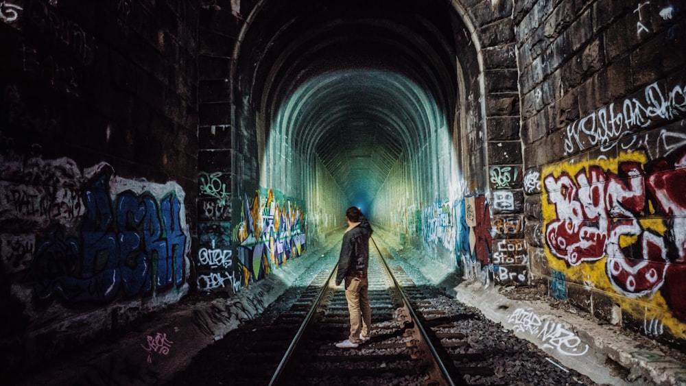 man standing near tunnel