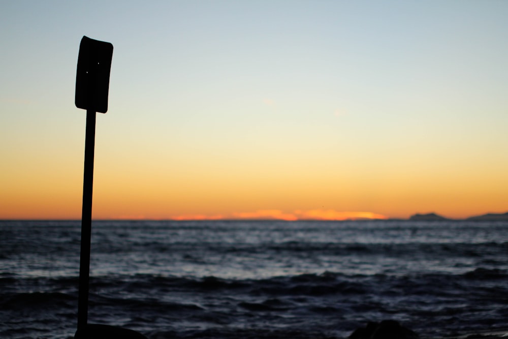 a street sign sitting on the side of a body of water