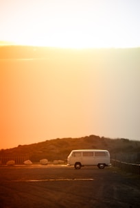 A sleek white van parked on a scenic road with clear interior shots visible through the windows