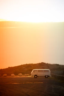 A spacious white family van ready for a road trip parked in a sunny countryside setting