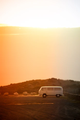 A spacious white family van ready for a road trip parked in a sunny countryside setting