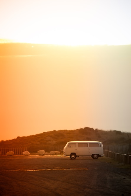 A sleek white van parked on a scenic road with clear interior shots visible through the windows