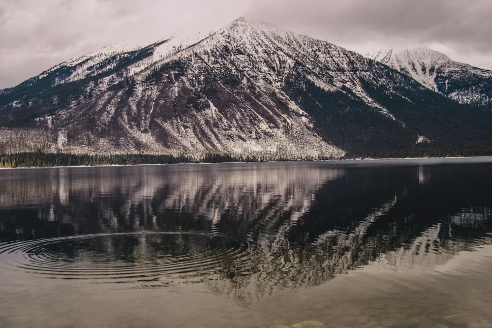 silhouette photo of lake beside mountain