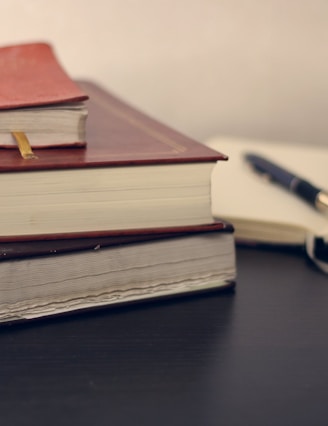 selective focus photography of three books beside opened notebook