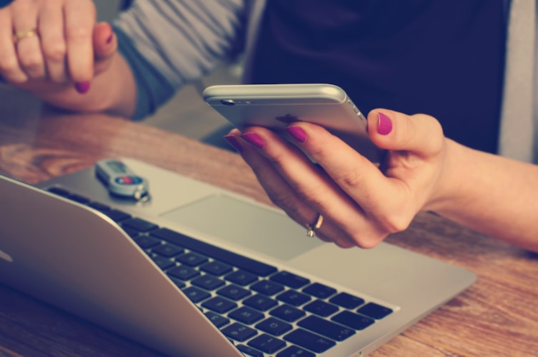 girl simultaneously using phone and laptop