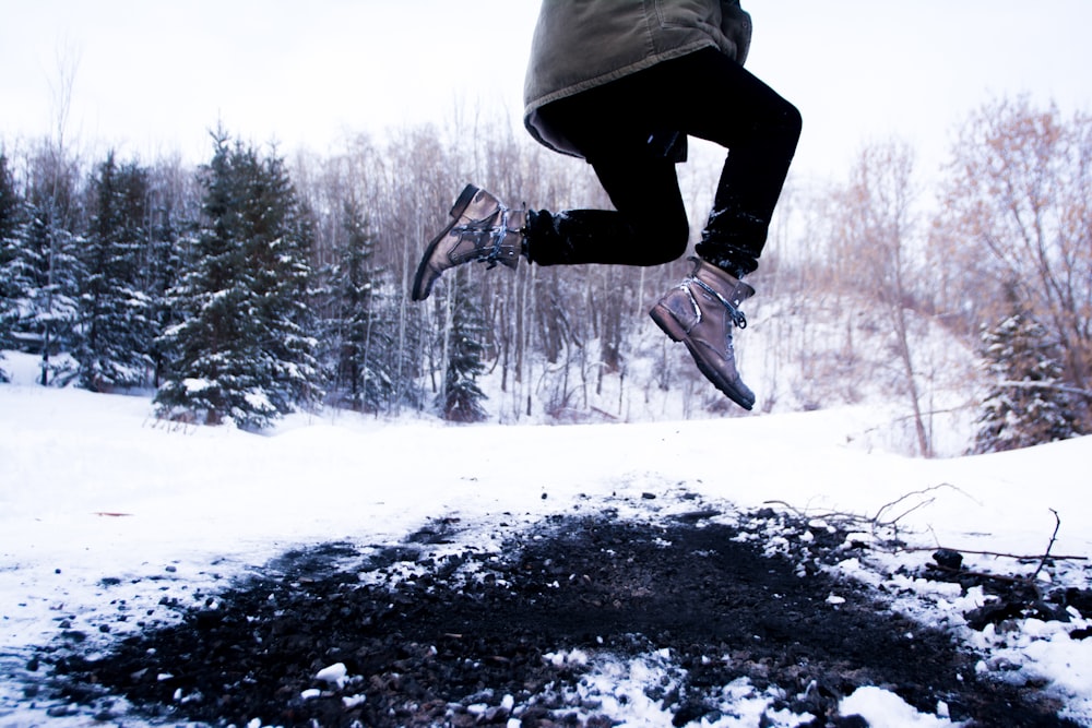 person jumping over black soil