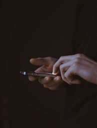 silhouette photo of person holding smartphone