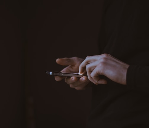 silhouette photo of person holding smartphone