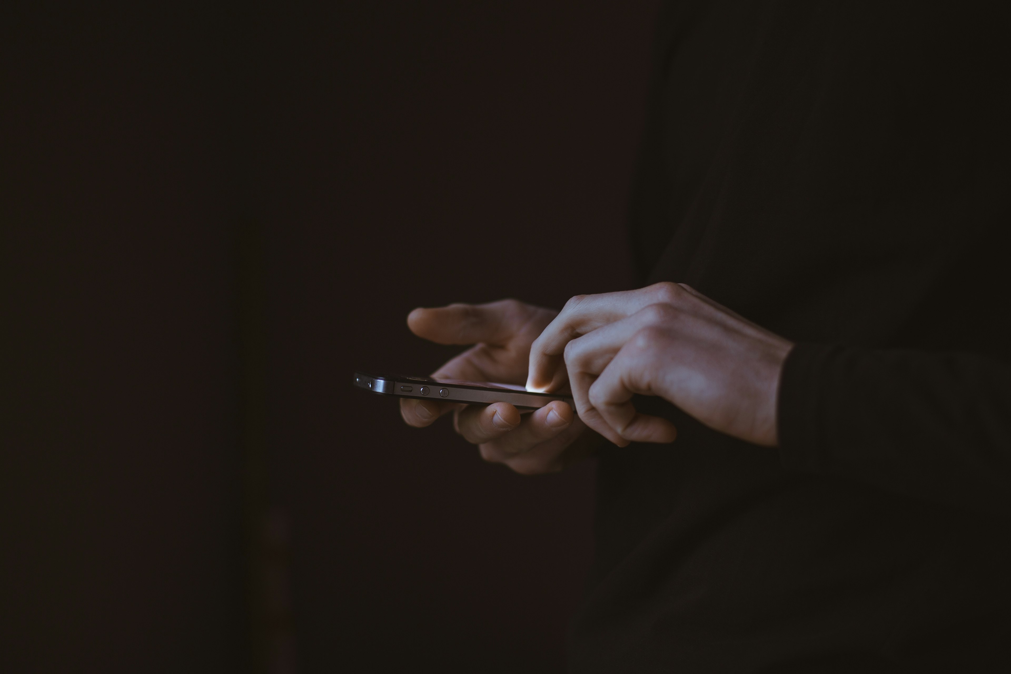 Silhouette photo of person holding smartphone