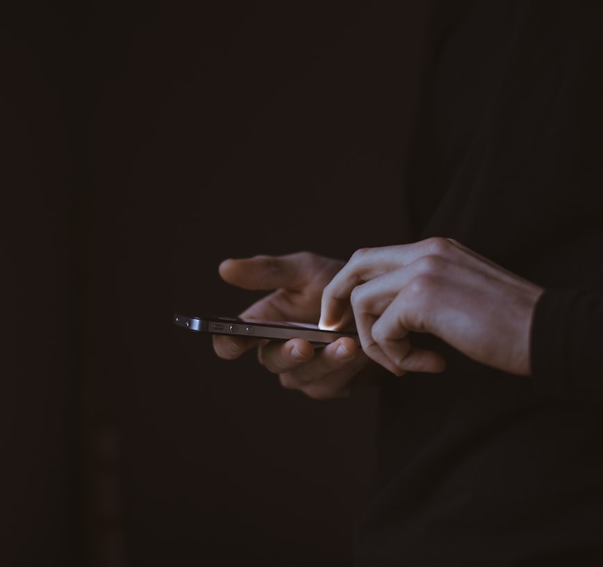 silhouette photo of person holding smartphone