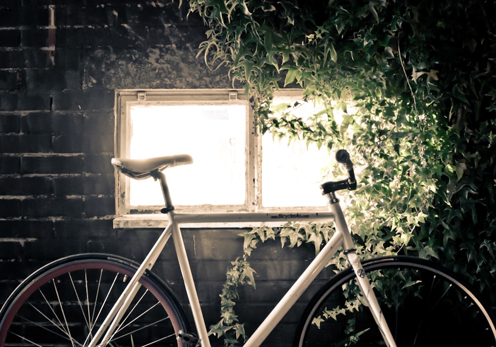 Bicicleta blanca de piñón fijo dentro de la habitación negra