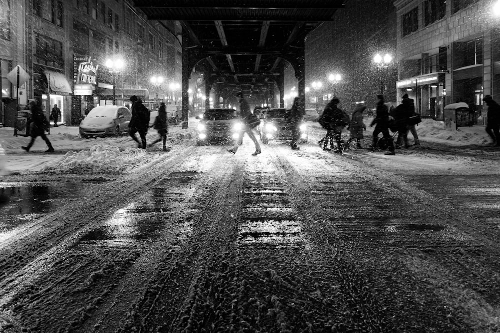 Foto in scala di grigi di persone che camminano per strada