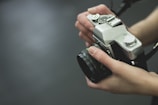 A detailed shot of hands holding a vintage camera in soft focus.